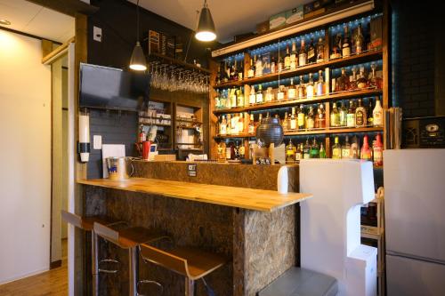 a bar with a wooden counter and a refrigerator at グッドタイム細越 in Aomori