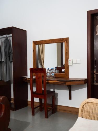 a dressing table with a chair and a mirror at Sanna Suite Villa in Siem Reap