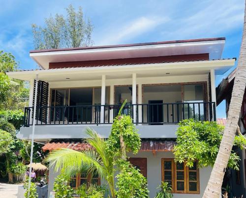 a white house with a balcony and trees at Big Fish Resort Koh Tao in Koh Tao