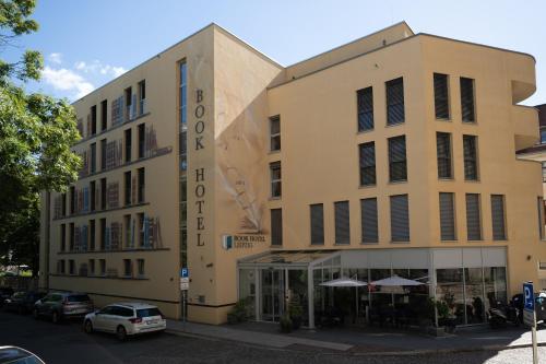 a building on a street with cars parked in front of it at Book Hotel Leipzig in Leipzig