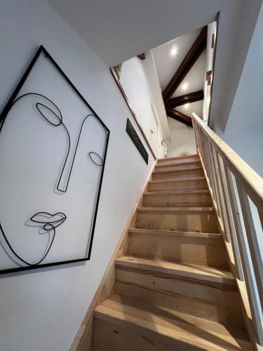 a staircase with a painting of a spoon on the wall at Cocon de charme in La Chapelle-Gonaguet