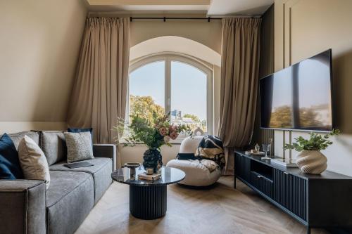a living room with a couch and a tv at Azure Palace - LoftAffair Collection in Kraków