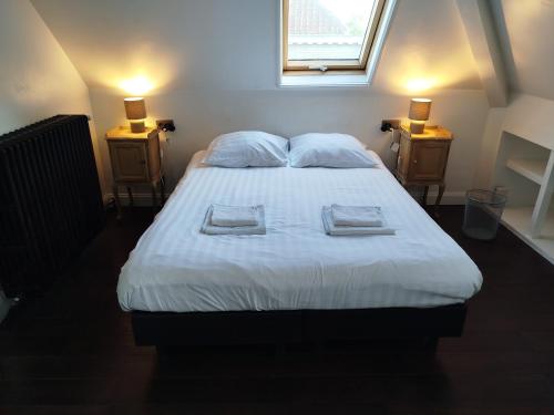 a bedroom with a bed with two towels on it at B&B Pickery in Bruges