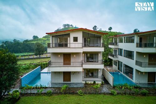 an aerial view of a building with a swimming pool at StayVista at Mount Brook with Mountain views, AC, Lawn in Igatpuri