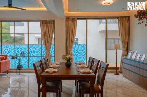 a dining room with a table and chairs at StayVista at Mount Brook with Mountain views, AC, Lawn in Igatpuri
