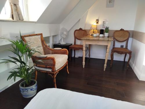 a room with two chairs and a table with a plant at B&B Pickery in Bruges