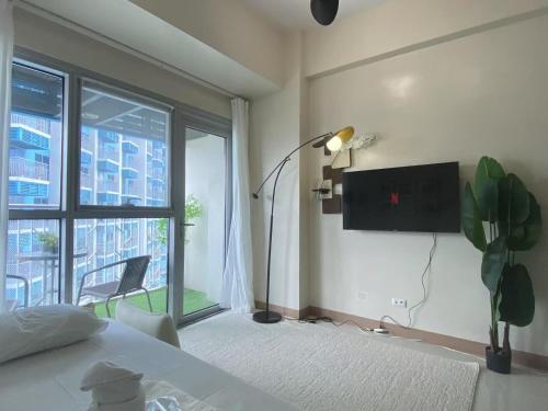 a bedroom with a bed and a tv on the wall at Playful 1BR With Magnificant Bayview Garden View Near Okada Solaire Aiports with Free Parking in Manila