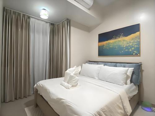 a bedroom with a large bed with white pillows at Playful 1BR With Magnificant Bayview Garden View Near Okada Solaire Aiports with Free Parking in Manila