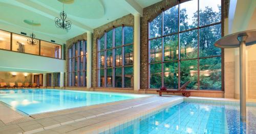a large swimming pool in a large room with windows at Wille Bali Indah in Słupsk