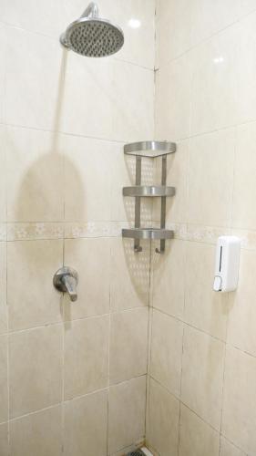 a shower with a shower head in a bathroom at Diyar Villas Puncak M6/50 in Puncak