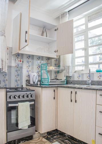 a kitchen with white cabinets and a stove at Naivasha Vacation Homes - Villaview in Naivasha