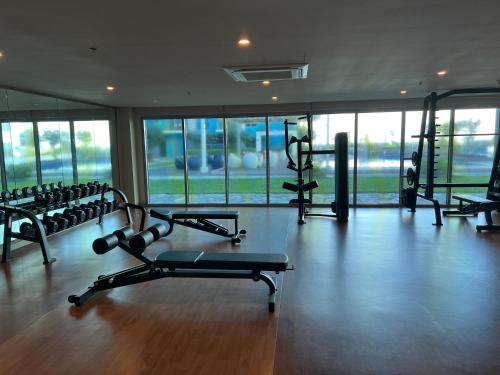 a gym with several tread machines in a room with windows at Playful 1BR With Magnificant Bayview Garden View Near Okada Solaire Aiports with Free Parking in Manila
