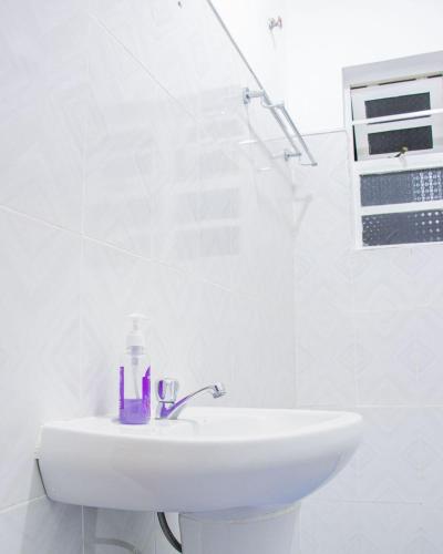 a white bathroom with a sink and a shower at Naivasha Vacation Homes - Villaview in Naivasha