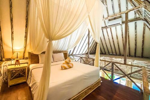 a bedroom with a bed with a teddy bear sitting on it at Villa Alisha Pererenan Canggu in Canggu