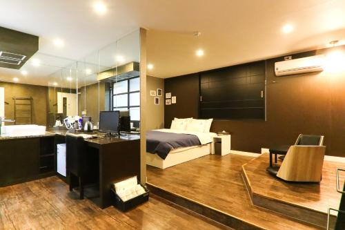 釜山にあるルイス ホテルの部屋にベッドと机がある寝室