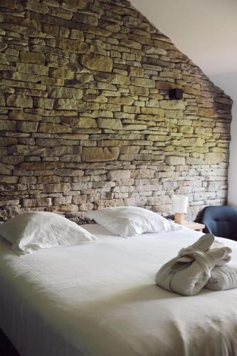 a bedroom with a brick wall and a bed with pillows at Le Domaine de Bra in Bra