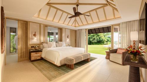 a bedroom with a bed and a living room at Four Seasons Resort Mauritius at Anahita in Beau Champ