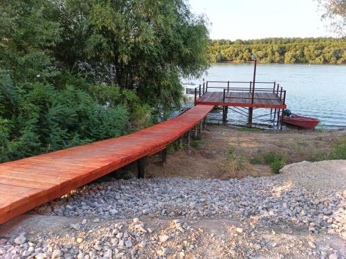 a wooden bridge over a lake with a dock at Casa delta verde in Mahmudia