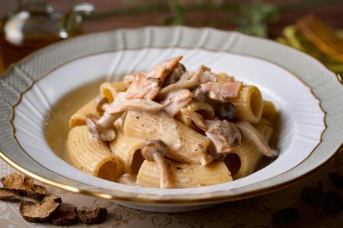 a bowl of pasta with chicken and mushrooms on a table at Ooedo Onsen Monogatari Hotel Ranpu in Hirado