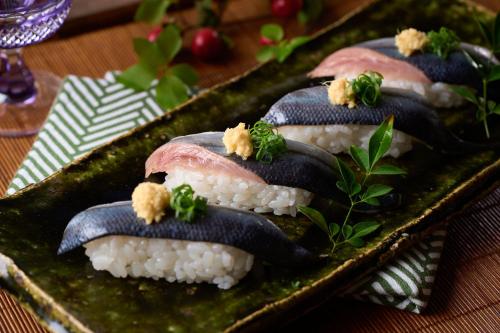 a plate of sushi with fish on top of rice at Ooedo Onsen Monogatari Hotel Ranpu in Hirado