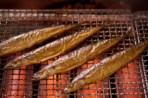 three fish sitting on a rack on a grill at Ooedo Onsen Monogatari Hotel Ranpu in Hirado