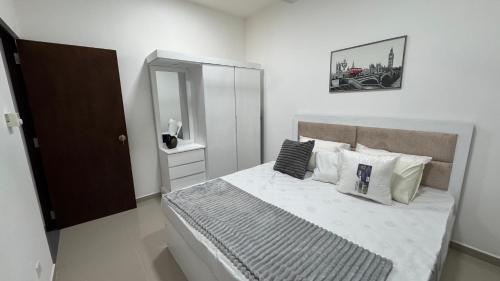a bedroom with a large bed with white sheets and pillows at Modern 2BR Resort Apartment with Pool & Gym, Malabe in Malabe