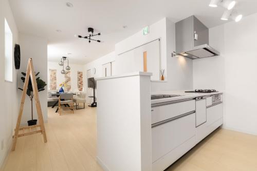 a kitchen with white appliances and a dining room at Megumi in Osaka