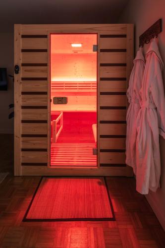 a room with a red door with a red rug at L'Escapade Secrète balnéo - sauna - love room in Arras