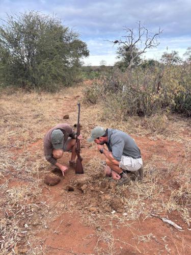 two men working on a pole in a field at Mohlabetsi Safari Lodge in Hoedspruit