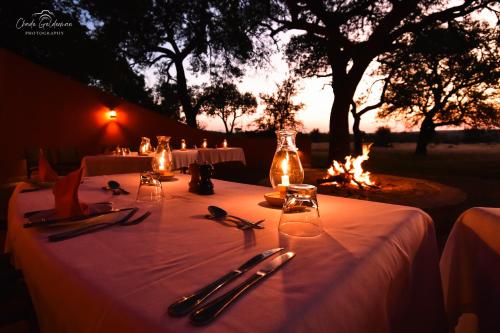 a table with a white table cloth and a fire place at Mohlabetsi Safari Lodge in Hoedspruit
