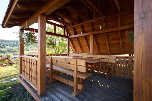 a porch of a wooden cabin with a bench at OneLife Retreat 