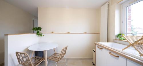 a kitchen with a table and chairs and a sink at L'Escapade Secrète balnéo - sauna - love room in Arras