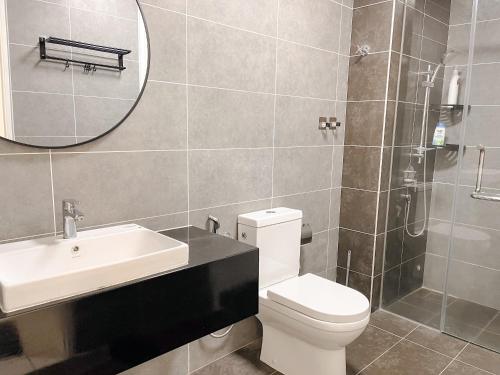 a bathroom with a toilet and a sink and a mirror at Onsen Premium Hotspring Suite Sunway Tambun Ipoh in Tambun