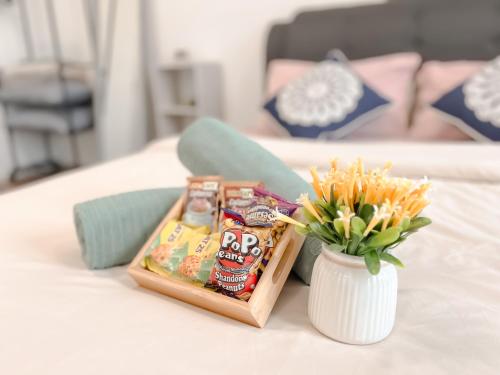 a table with a tray of snacks and a vase with flowers at Onsen Premium Hotspring Suite Sunway Tambun Ipoh in Tambun