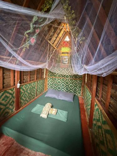 a room with a green bed in an attic at Jonny's Hostel in San Juan