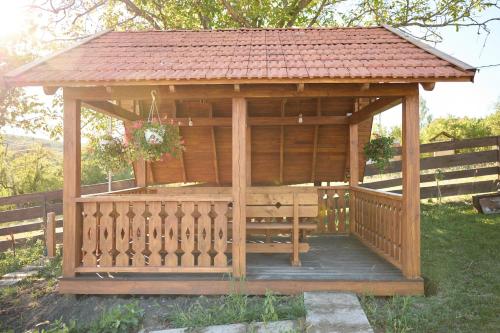 a wooden gazebo with a red roof at OneLife Retreat 