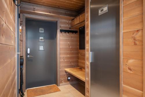 a walk in closet with a gray door and wooden walls at Panoramahytte med fjellutsikt in Sogndal