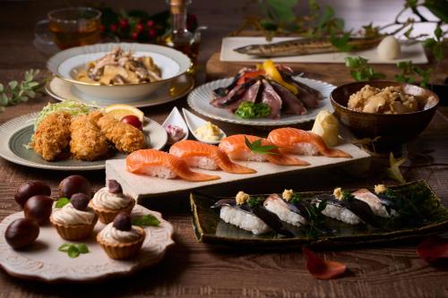 a table with many plates of food on it at Ooedo Onsen Monogatari Awazu Grand Hotel in Komatsu