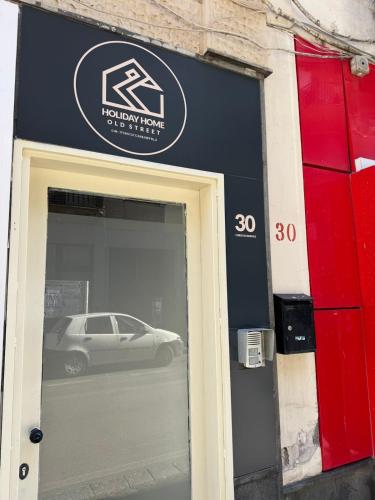 a car is reflected in the window of a store at Holiday Home Old Street in Scafati