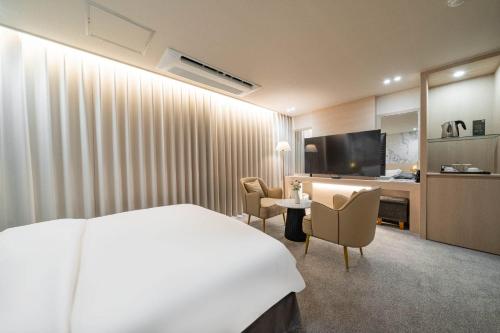 a hotel room with a bed and a desk at Benikea Hotel Bizinn in Wonju