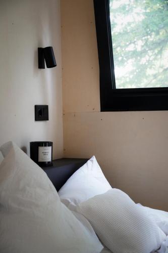 a bedroom with a white bed with a window at Tiny House für Naturliebhaber & Entdecker in Brand