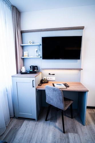 a desk with a chair and a television in a room at Hotel Seeschwalbe in Cuxhaven