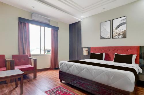 une chambre avec un grand lit avec une tête de lit rouge dans l'établissement Collection O Sun Temple Gwalior Formerly Sunshine Resort, à Gwalior