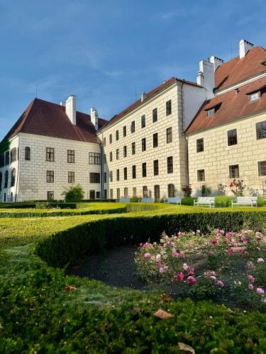a large building with a garden in front of it at Penzion U zámeckého parku in Třeboň
