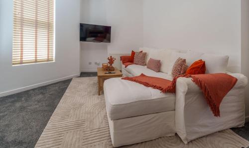 a living room with a white couch with red pillows at Modern 1 Bedroom Apartment - The Den in Plymouth