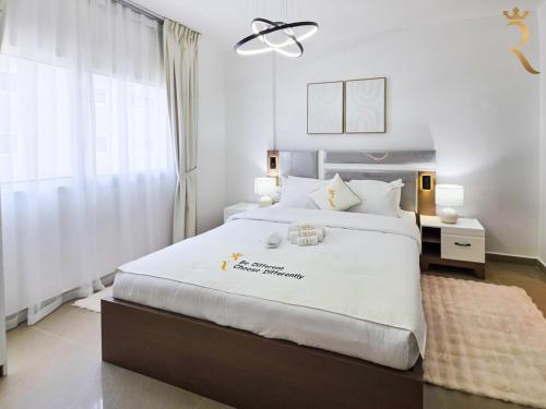 a bedroom with a large white bed and a window at Balcony 1BR Retreat - Stylish Dining Escape in Abu Dhabi