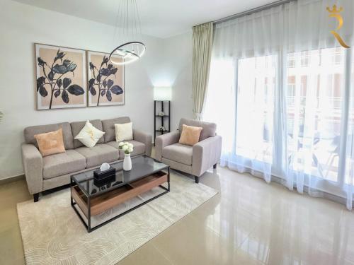 a living room with a couch and a table at Balcony 1BR Retreat - Stylish Dining Escape in Abu Dhabi