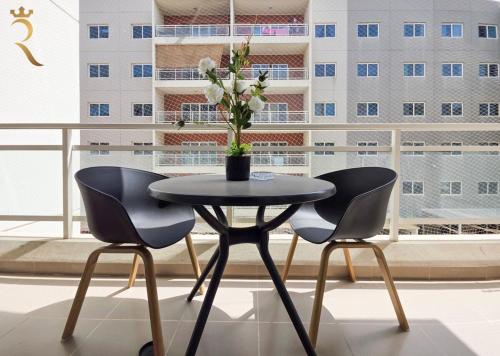 a black table with two chairs and a vase with flowers at Balcony 1BR Retreat - Stylish Dining Escape in Abu Dhabi