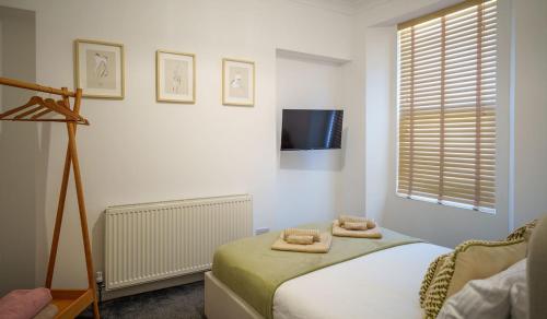 a bedroom with a bed with two towels on it at Modern 1 Bedroom Apartment - The Den in Plymouth