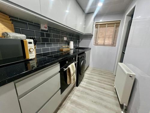 a small kitchen with a black counter top at Modern 1 Bedroom Apartment - The Den in Plymouth